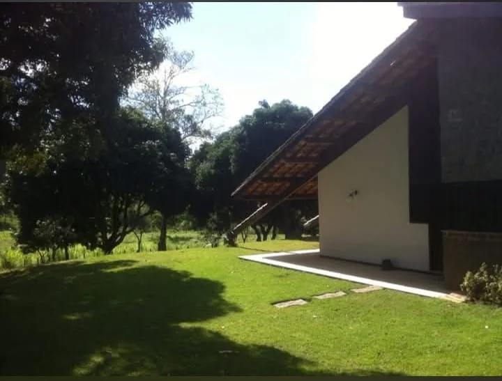 A casa-sede à luz do dia, com telhado colonial e gramado